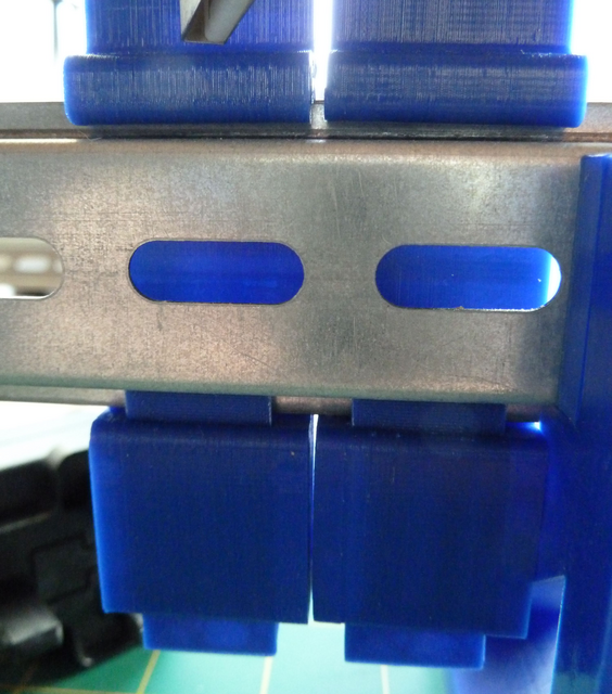 A locking tab fixes the mounting plate on the rail